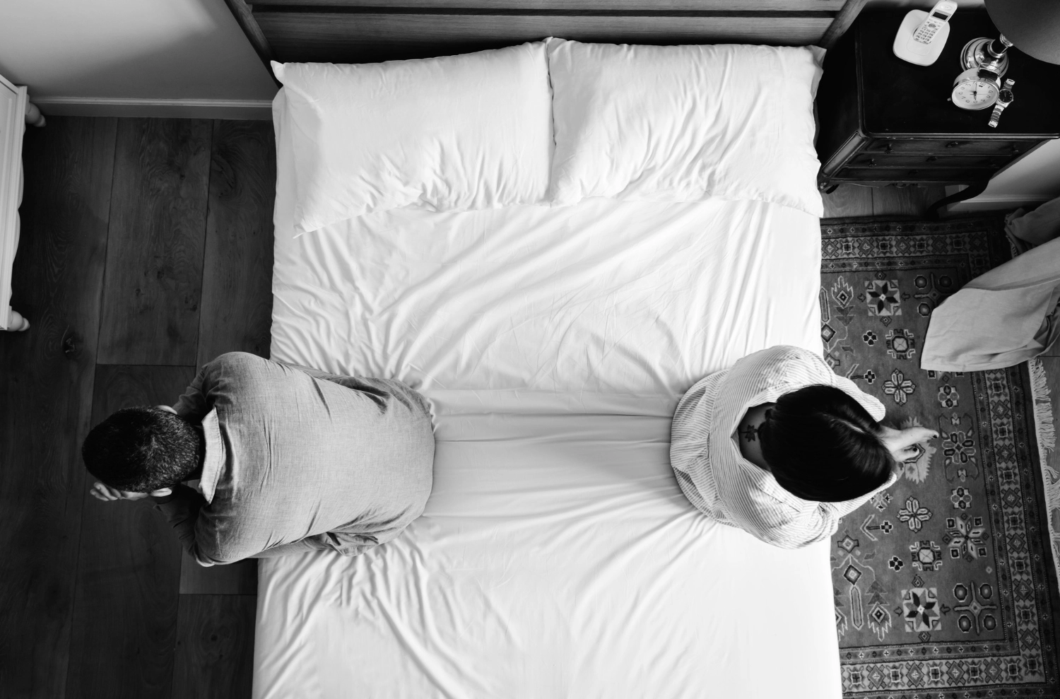Una pareja sentada en una cama a punto de pensar en el divorcio express